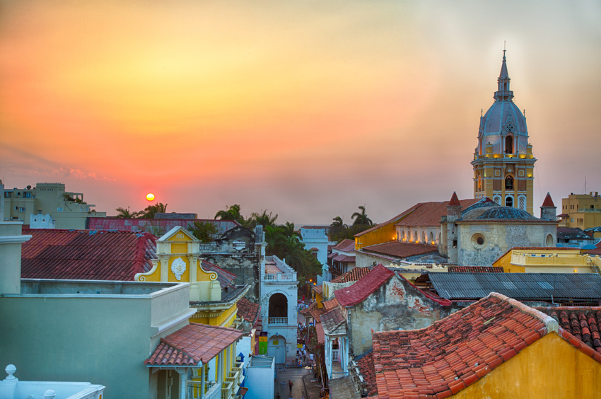 View over the rooftops of the old city of Cartagena during a vibrant sunset. The spire of Cartagena Cathedral stands tall and proud.